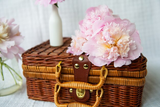 Beautiful bouquet of pink peonies on a wooden suitcase