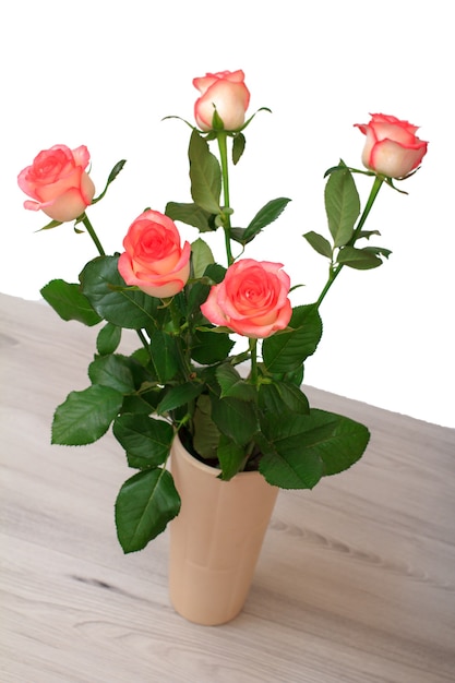 Bellissimo bouquet di rose rosa in vaso di ceramica sul tavolo in uno sfondo bianco. concetto di celebrazione.