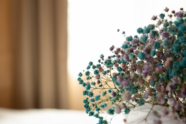 Photo beautiful bouquet on table in bedroom space for text vase with beautiful small blue flowers on desk