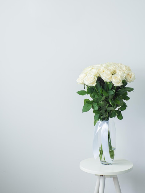 Bellissimo bouquet di rose bianche in vaso di vetro su tavola rotonda