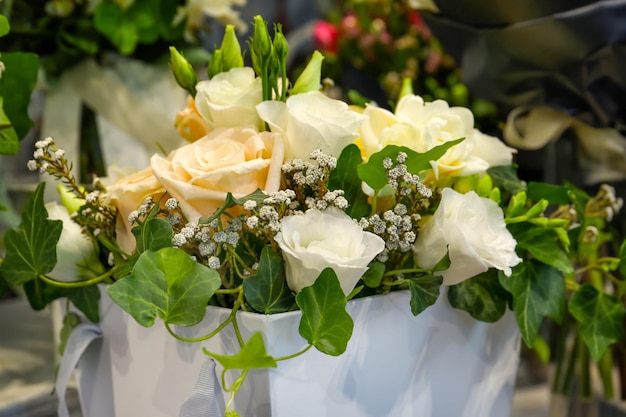 Beautiful bouquet of white festive flowers in packaging box closeup