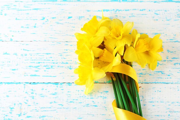 Beautiful bouquet of yellow daffodils on wooden background