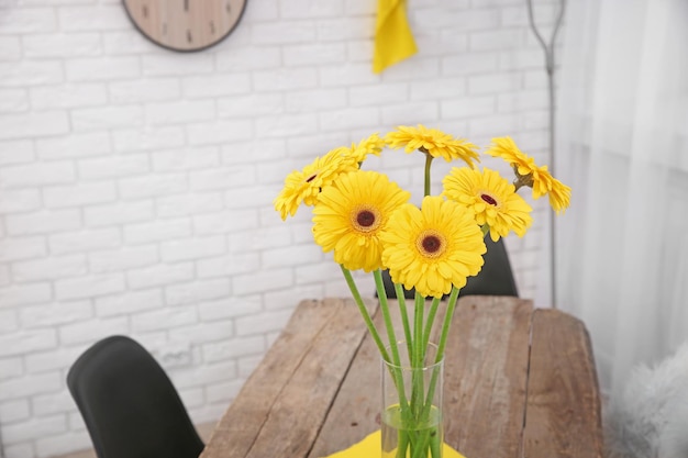 木製のテーブルに黄色いガーベラの花の美しい花束