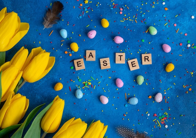 Beautiful bouquet of yellow tulips with sugar eggs and sprinkles Easter background