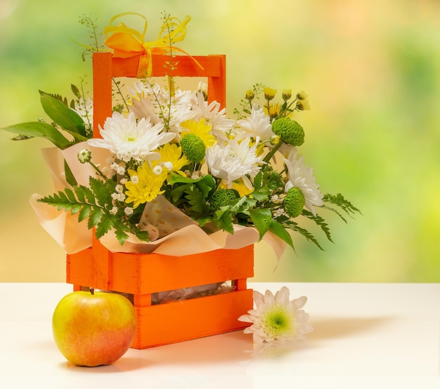 Beautiful bouquet of yellow and white flowers with wooden basket