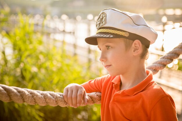 Photo beautiful boy is about rope in the captain's cap