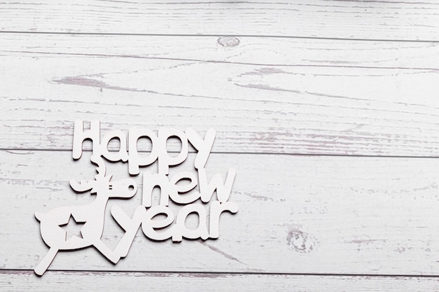 beautiful branches of a Christmas tree with cones and toys on a white wooden background with the inscription Happy New Year closeup