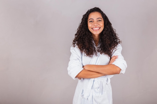 Beautiful Brazilian black woman wearing bathrobe and towel curly hair spa beauty center hair care crossed arms