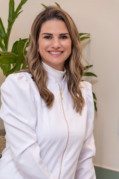 Beautiful Brazilian Caucasian Woman Professional Beautician Cosmetologist Smiling happy and optimistic posing for photo