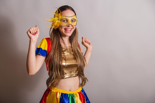 Beautiful brazilian caucasian woman wearing frevo carnival\
clothes wearing a mask dancing