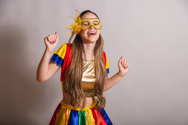 Beautiful brazilian caucasian woman wearing frevo carnival
clothes wearing a mask dancing