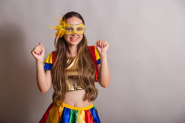 Beautiful brazilian caucasian woman wearing frevo carnival
clothes wearing a mask dancing