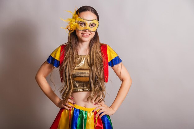 Beautiful brazilian caucasian woman wearing frevo carnival\
clothes wearing a mask hands on hips