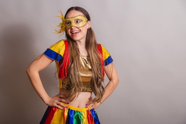 Beautiful brazilian caucasian woman wearing frevo carnival
clothes wearing a mask hands on hips