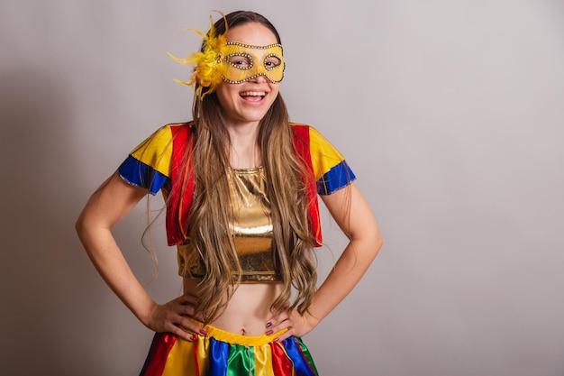 Beautiful brazilian caucasian woman wearing frevo carnival\
clothes wearing a mask hands on hips