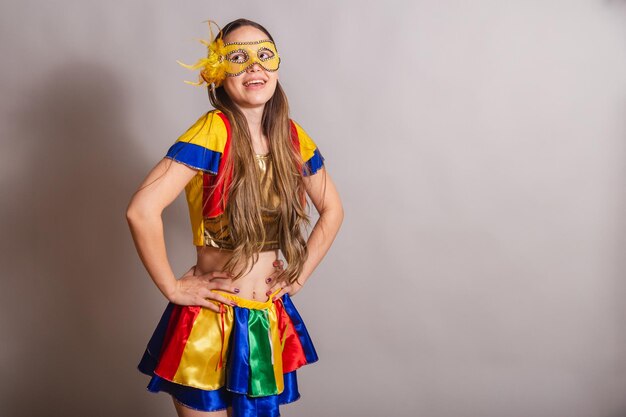 Beautiful brazilian caucasian woman wearing frevo carnival
clothes wearing a mask hands on hips