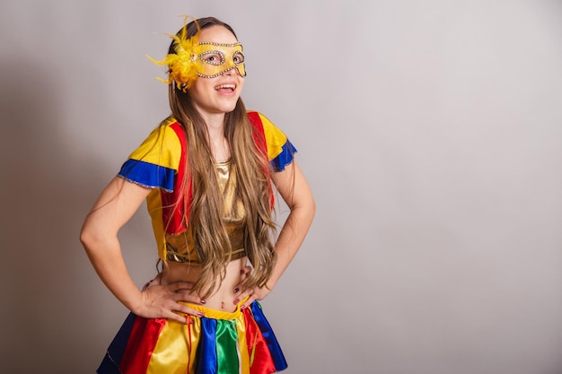 Beautiful brazilian caucasian woman wearing frevo carnival
clothes wearing a mask hands on hips