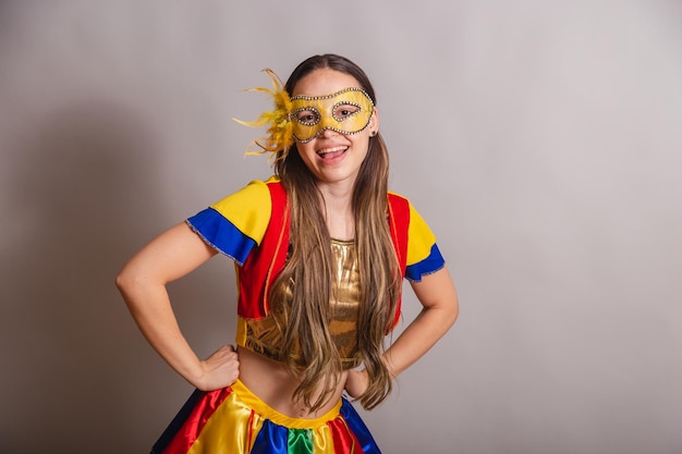 Beautiful brazilian caucasian woman wearing frevo carnival\
clothes wearing a mask hands on hips