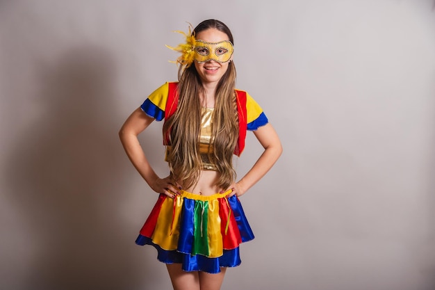 Beautiful brazilian caucasian woman wearing frevo carnival
clothes wearing a mask hands on hips