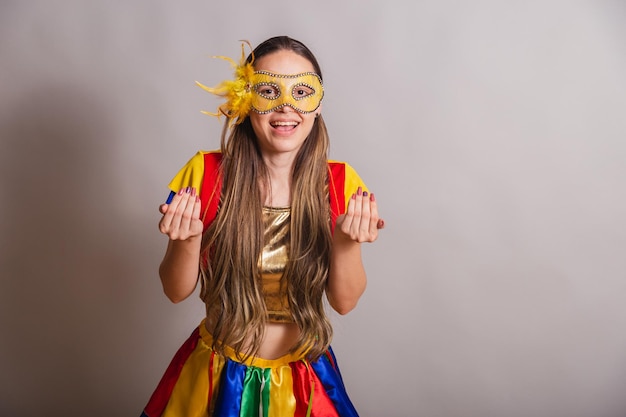 Beautiful brazilian caucasian woman wearing frevo carnival\
clothes wearing a mask inviting with hands come