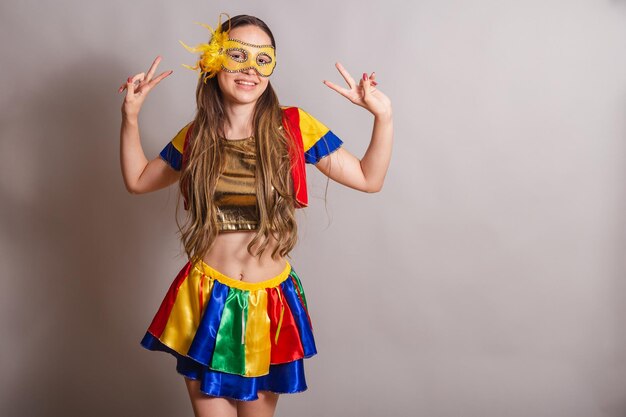 Beautiful brazilian caucasian woman wearing frevo carnival\
clothes wearing a mask peace and love