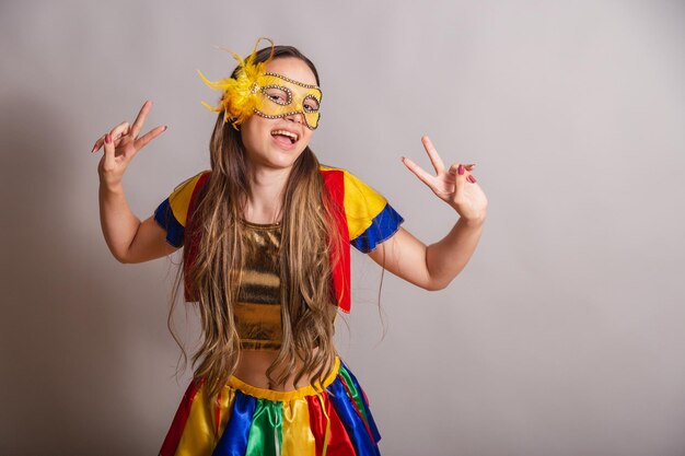 Beautiful brazilian caucasian woman wearing frevo carnival\
clothes wearing a mask peace and love