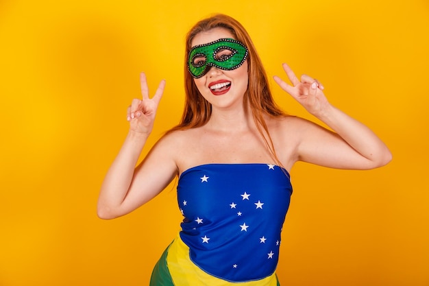 Beautiful brazilian redhead girl with carnival clothes made with flag of brazil