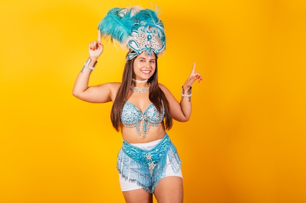 Beautiful Brazilian woman in blue and white carnival clothes with crown of feathers smiling dancing partying