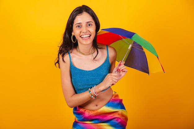 Beautiful brazilian woman in carnival clothes holding colorful umbrella