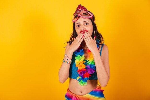 Beautiful brazilian woman in carnival clothes wearing carnival mask flower necklace blowing kiss