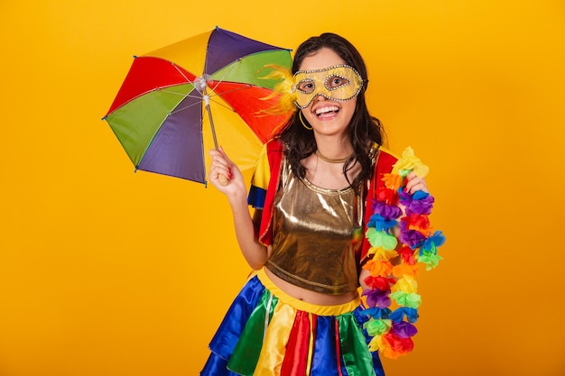 Beautiful brazilian woman in carnival clothes with frevo clothes and colorful umbrella and flower necklace