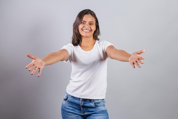 Beautiful brazilian woman denim and white with open arms for a hug