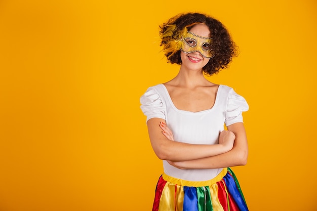 Beautiful Brazilian woman dressed in carnival clothes colorful skirt and white shirt crossed arms