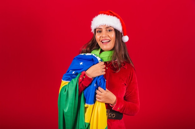 Beautiful brazilian woman dressed in christmas clothes santa claus holding brazil flag
