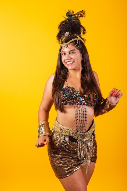 Beautiful brazilian woman in golden carnival clothes dancing enjoying and partying vertical photo