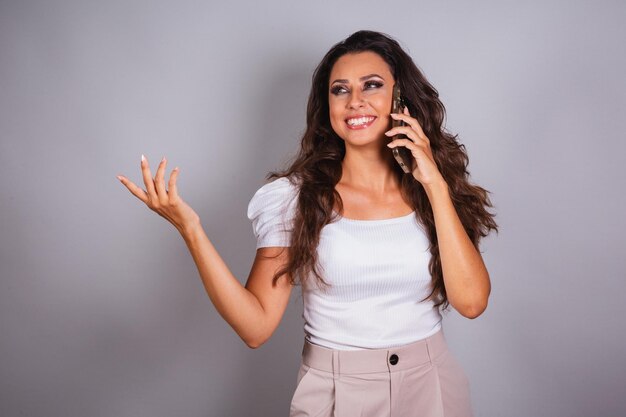 Foto bella donna brasiliana che tiene la chiamata vocale dello smartphone che parla