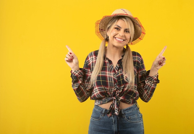 Beautiful brazilian woman with festa junina clothes on yellow background