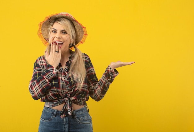 Beautiful brazilian woman with festa junina clothes on yellow background