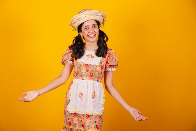 Beautiful brazilian woman with june party clothes laughing with open arms welcome