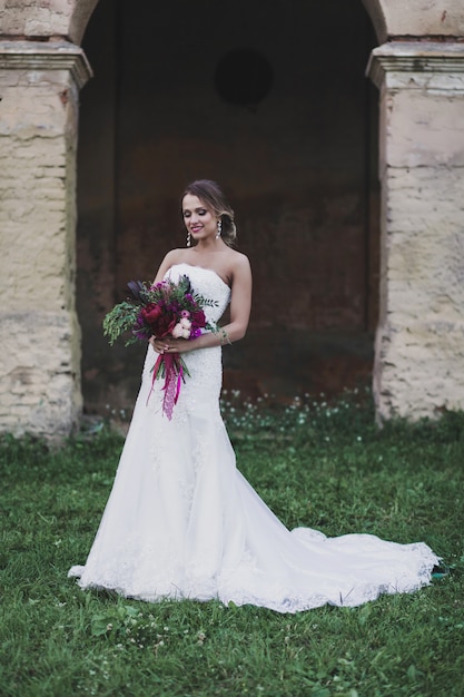 Bella ragazza nuziale con bouquet di fiori