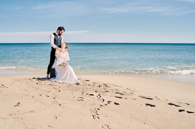 Фото Красивая невеста и жених на пляже, глядя друг на друга с большой любовью и радостью