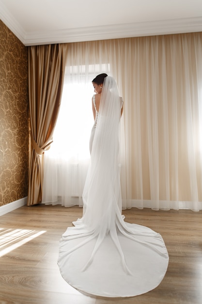 ホテルの部屋で屋内シックなロングドレスの美しい花嫁