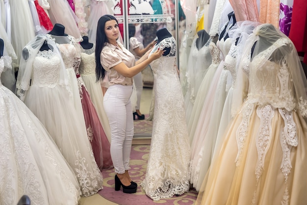 Красивая невеста, выбирая свадебное платье в салоне
