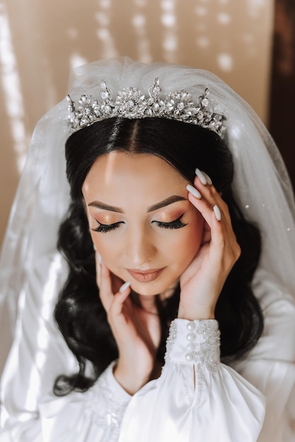 Beautiful bride in a dressing gown in the morning before the wedding ceremony Incredible hairstyle of the bride Natural and modern makeup Portrait of a young bride in a dressing gown