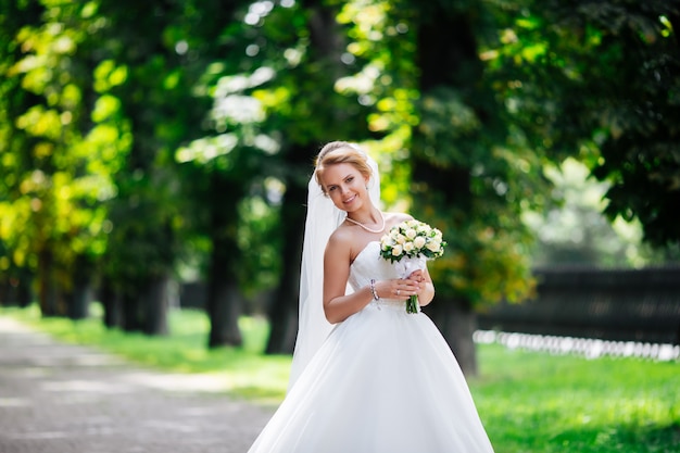 Beautiful bride in fashion wedding dress on natural background.The stunning young bride is incredibly happy. Wedding day.