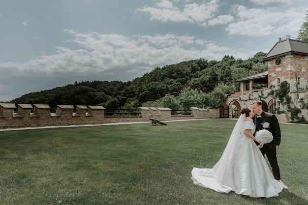 Beautiful bride and groom embracing and kissing on their wedding day outdoors