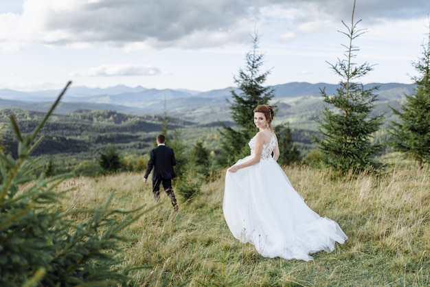 Beautiful bride and groom at the mountains