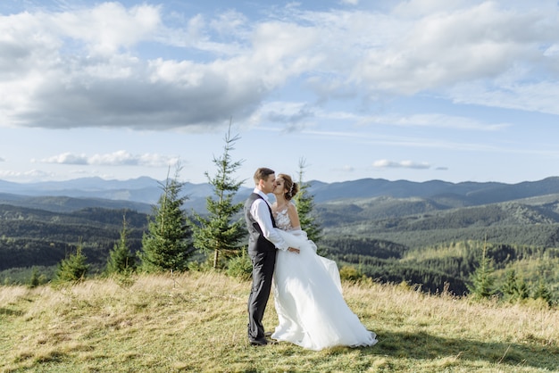 Beautiful bride and groom at the mountains