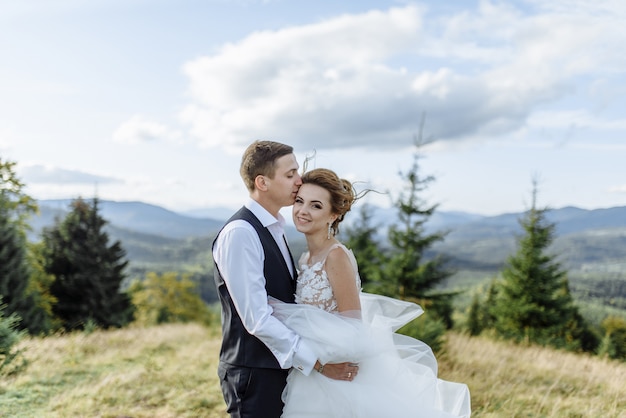 Beautiful bride and groom at the mountains