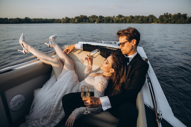 Beautiful bride and groom ride a yacht drink wine and enjoy the moment Wedding day